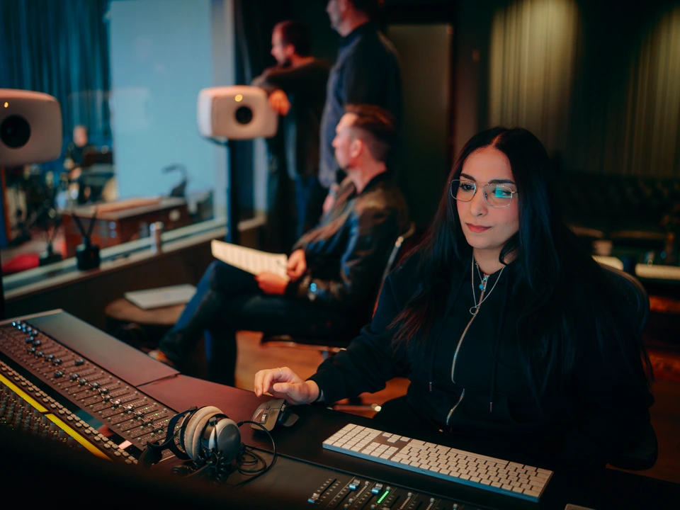 A team listening and working together at the studio console