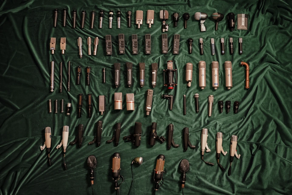 The studio’s microphone collection arranged on green velvet
