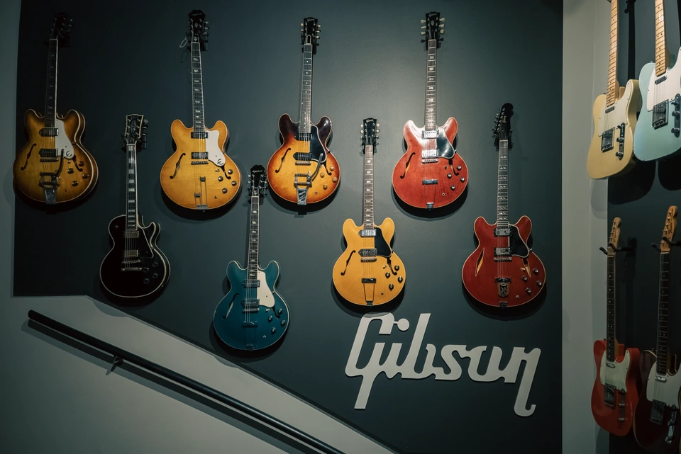 Semi-hollow and solid-body guitars displayed on the studio wall