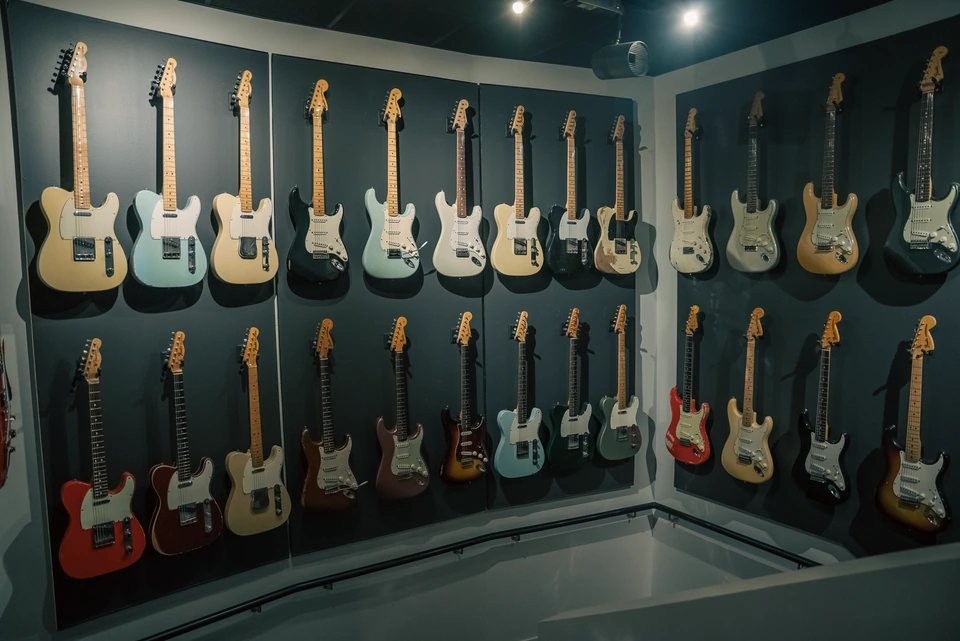 Two rows of electric guitars displayed on the studio wall